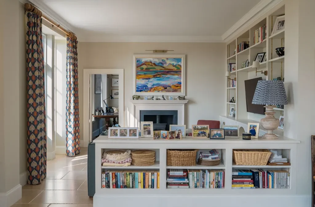  العمل الفني فوق المدفأة يجعل االتلفاز أقل حضورًا وهيمنة.( Novella Stories)